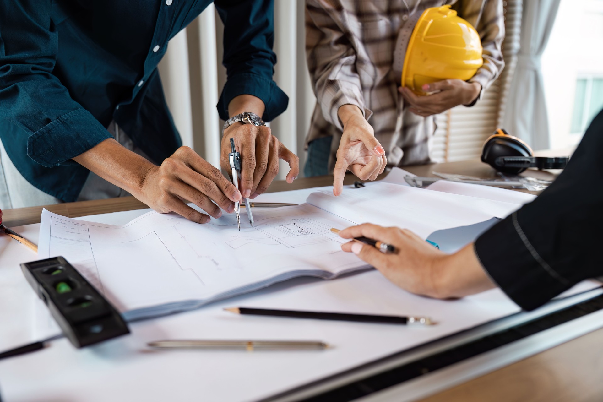 Architect collaboration on Blueprint Design at Construction Site with Tools and Safety Gear